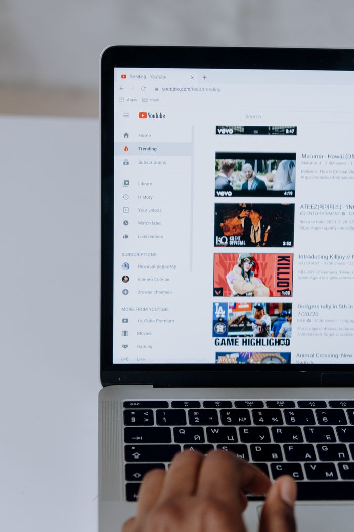 Une personne parcourt des vidéos YouTube sur un ordinateur portable, illustrant la technologie moderne et les contenus en ligne.
